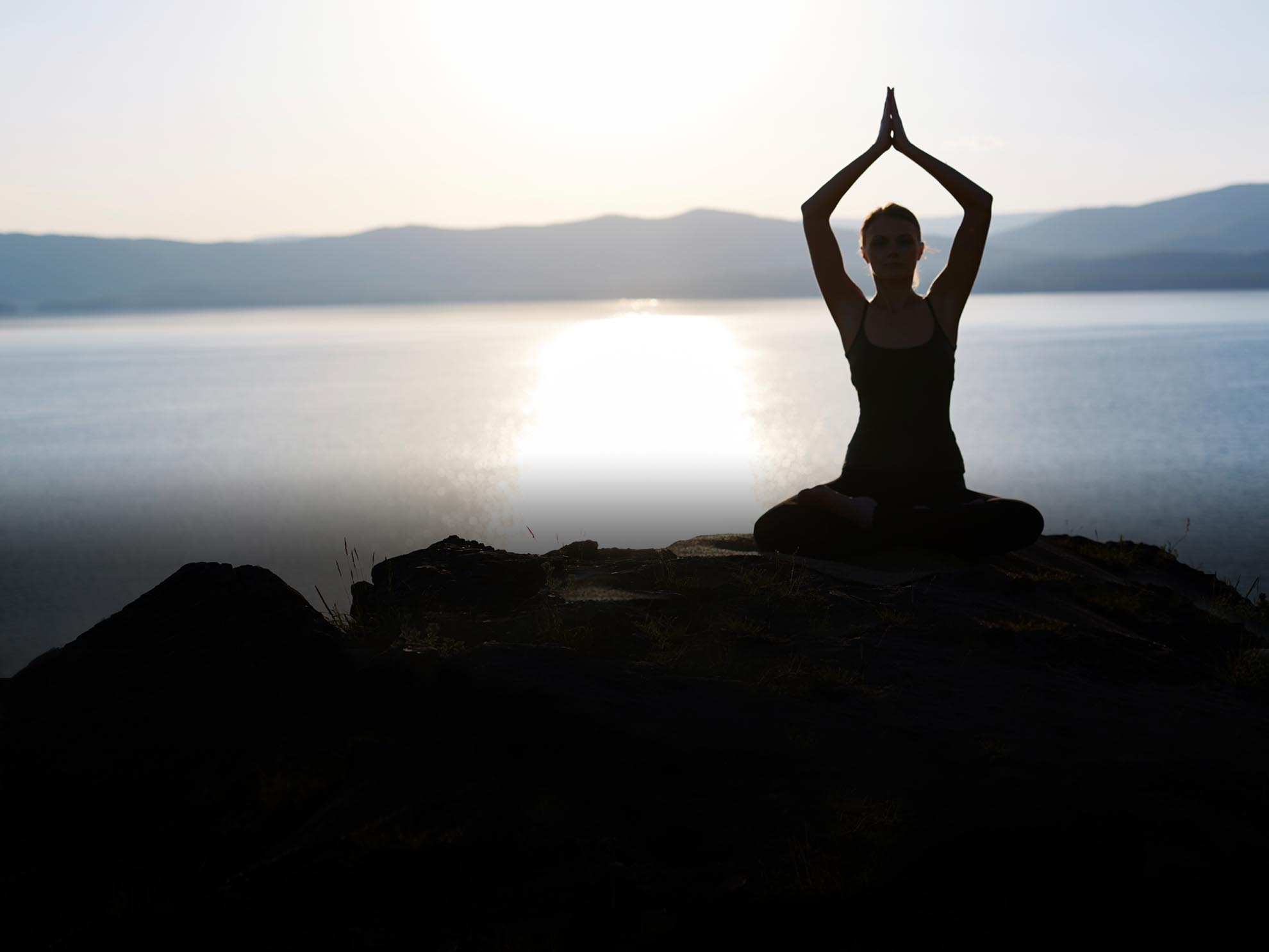 Woman in yoga pose on waterfront 