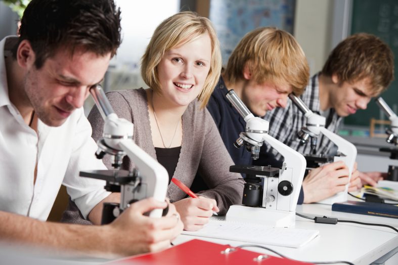 Students with microscopes in biology class
