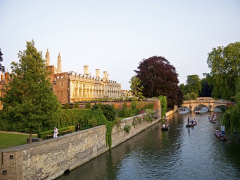 Cambridge, England - June 26,2010 Students punting on the River Cam a late summer evening when the sun goes down in Cambridge