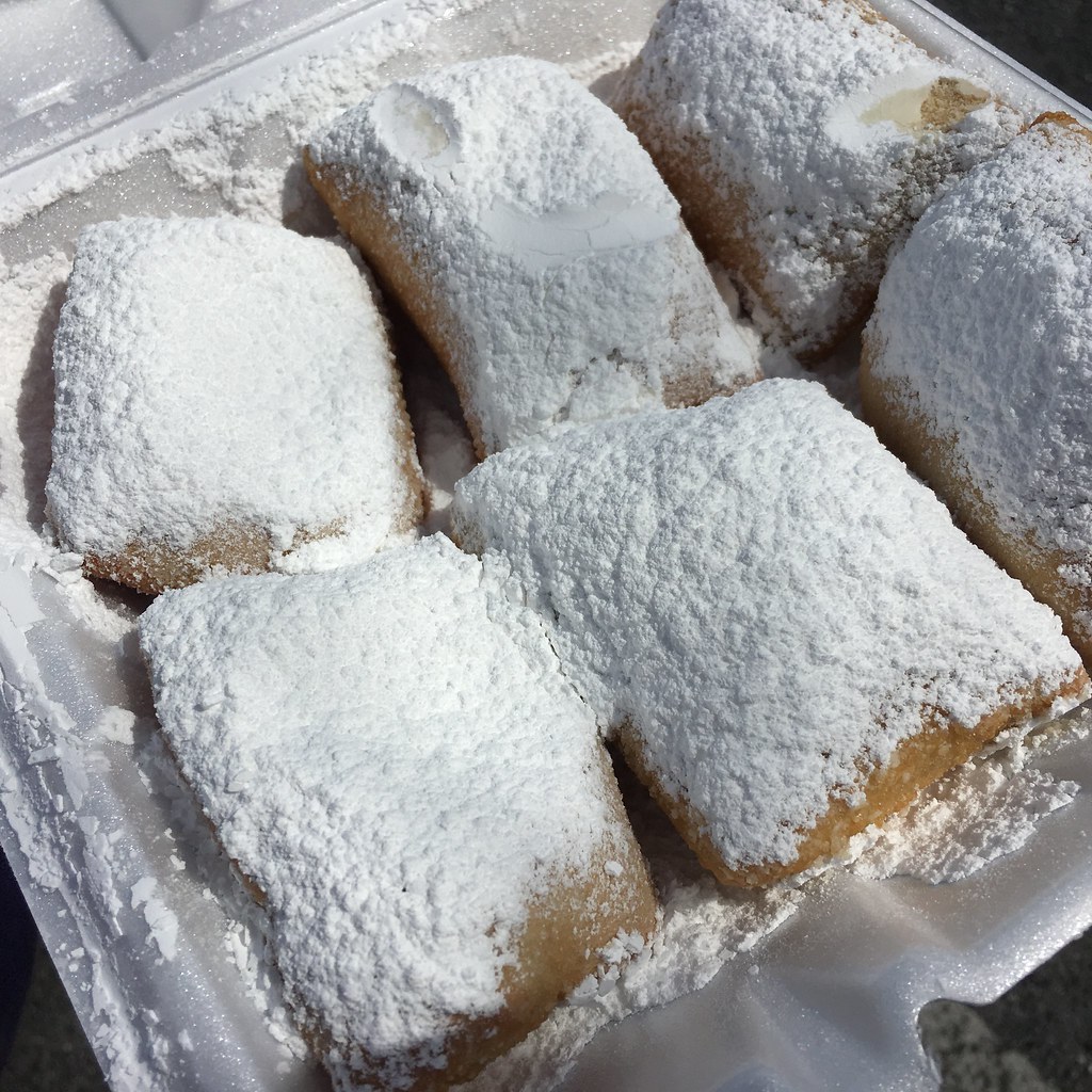 Photo of powdered sugar covered beignets in a box