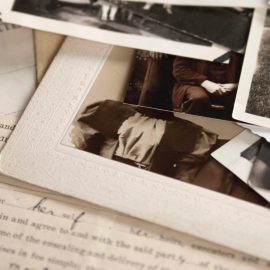 Pile of photographs sitting on top of a handwritten letter