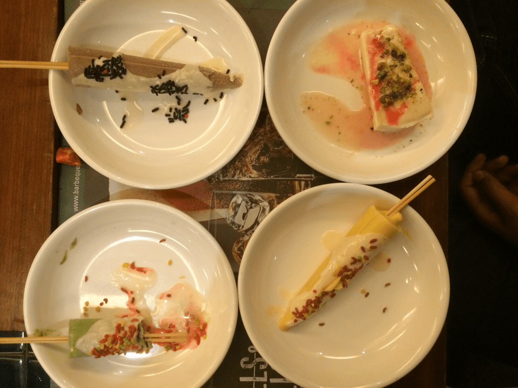 4 plates containing different forms of kulfi 