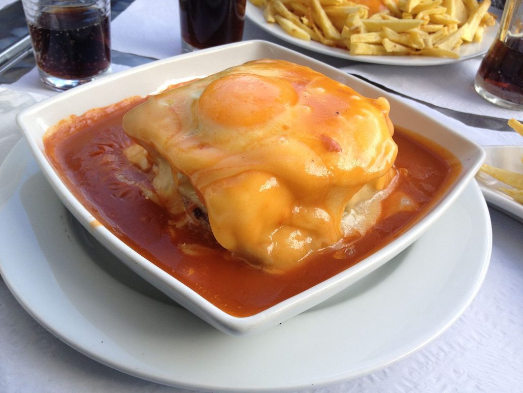 francesinha sandwich topped with an egg 